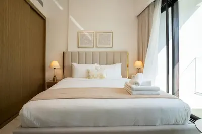 a bedroom with a large white bed with two lamps at Airstay - Chic Studio in Meydan Azizi 65 - Monthly Offer Available in Dubai