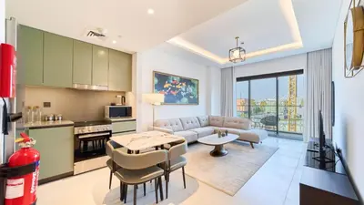 a kitchen and living room with a couch and a table at Stylish 1 Bedroom in Viridian City Walk in Dubai