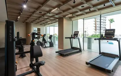 a gym with several treadmills and elliptical machines at Binghatti Royale Luxe 1BR Serenity with Private Pool! in Dubai