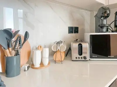 a kitchen counter with a microwave and some utensils at Warm Minimal 1BR in Binghatti Tulip with Free Parking! in Dubai