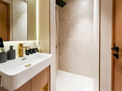 a bathroom with a white sink and a shower at Binghatti Azure Ethereal Studio Haven with Pool & Gym! in Dubai