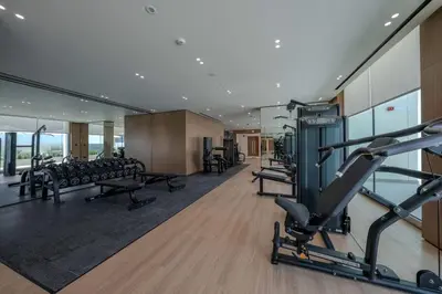 a gym with treadmills and machines in a building at Binghatti Azure Ethereal Studio Haven with Pool & Gym! in Dubai