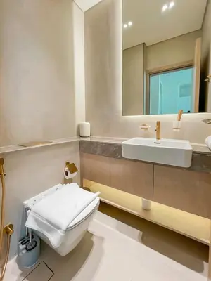 a bathroom with a sink and a toilet and a mirror at Calm 1BR Haven with Private Pool in Binghatti Royale in Dubai