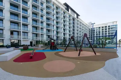 an empty playground in front of a building at Softline Studio with Open Views in Binghatti Phoenix! in Dubai