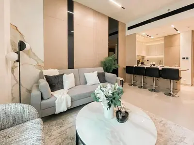 a living room with a couch and a table at Family-Friendly 1BR Apt with Study Room and Pool Views! in Dubai