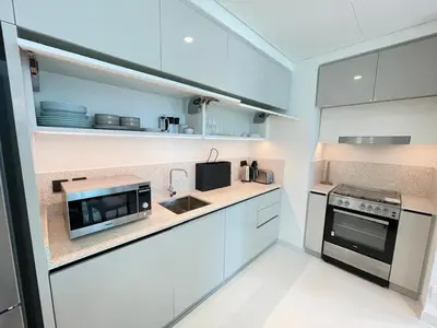 a kitchen with white cabinets and a microwave at Stunning and Cozy Home with Marina and Sea View in Dubai