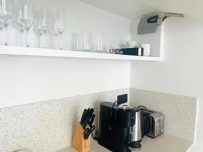 a kitchen counter with wine glasses on a shelf at Stunning and Cozy Home with Marina and Sea View in Dubai
