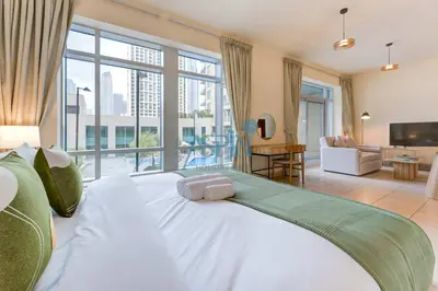a large white bed in a room with a large window at Aspin Brand New Premium Studio with Pool View - Burj Views in Dubai