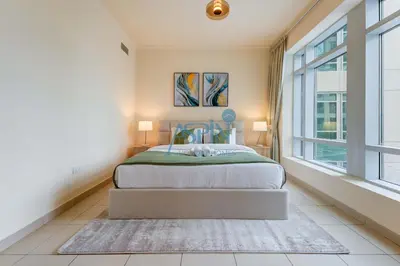 a bedroom with a bed and a large window at Aspin Brand New Premium Studio with Pool View - Burj Views in Dubai