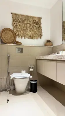 a white bathroom with a toilet and a sink at 2 Bed with Direct Park Access - Calm and Peaceful in Dubai