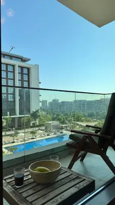 a balcony with a chair and a bowl on a table at 2 Bed with Direct Park Access - Calm and Peaceful in Dubai