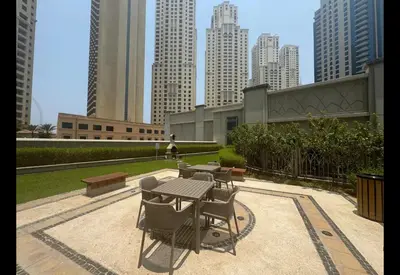 a picnic table and chairs in a park with tall buildings at Dubai Marina Penthouse Suite - Prime Location in Dubai