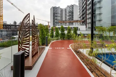 a red walkway in a city with buildings at Oxford Gardens Premium Studio with Cinema & Game Room in Dubai