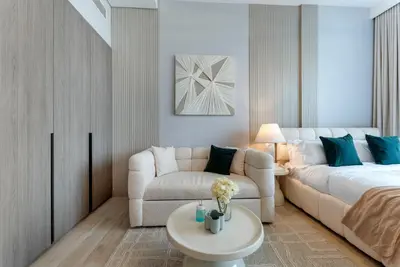 a living room with a bed and a couch and a table at Oxford Gardens Premium Studio with Cinema & Game Room in Dubai