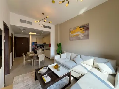 a living room with a white couch and a table at Werova - Urban Living 1BR Apartment in JVC in Dubai