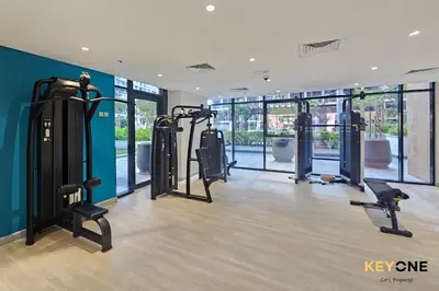 a gym with treadmills and elliptical machines at Stylish Riviera Studio Near Downtown in Dubai