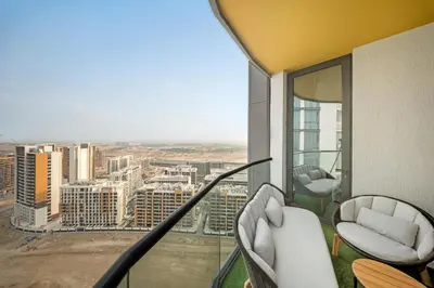 a room with a balcony with a view of a city at VayK - Stylish 2BR & Maids Apartment in Sobha Hartland in Dubai
