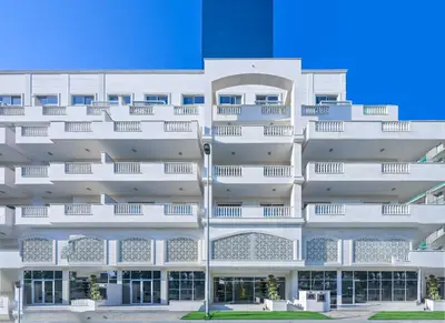 an external view of a white building at Relaxing 1BR Peaceful Family Living in JVC in Dubai