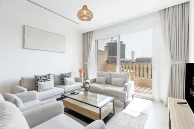 a living room with white furniture and a large window at Relaxing 1BR Peaceful Family Living in JVC in Dubai