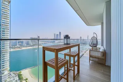 a room with a balcony with a view of the city at 2BR Beachfront Apartment at Palace Beach Residence in Dubai