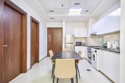 a kitchen with a table and chairs in a room at Urban and Central - 1BR at Binghatti Gateway in Dubai