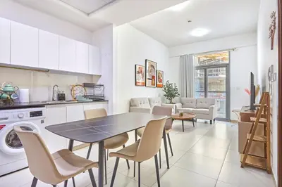 a kitchen and living room with a table and chairs at Urban and Central - 1BR at Binghatti Gateway in Dubai