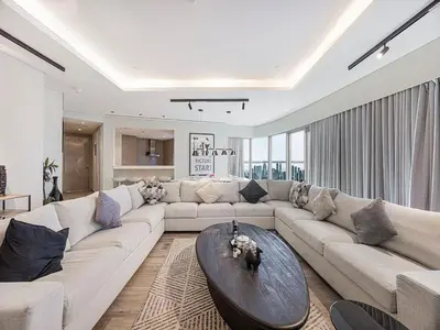 a living room with a large couch and a table at Spacious 3BR in Paramount Tower Luxury Living in Dubai