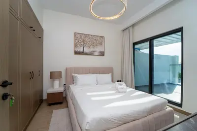 a bedroom with a large white bed and a window at Stylish 4 Bedroom Home with Garden in DAMAC Lagoons in Dubai Marina