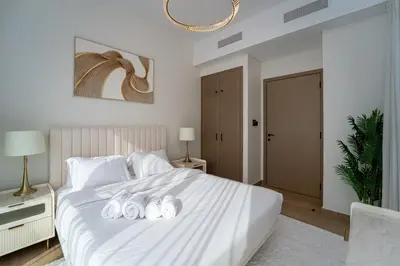 a bedroom with a large white bed with three shoes on it at Stylish 4 Bedroom Home with Garden in DAMAC Lagoons in Dubai Marina