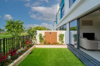 a backyard with green grass and a fence at Stylish 4 Bedroom Home with Garden in DAMAC Lagoons in Dubai Marina