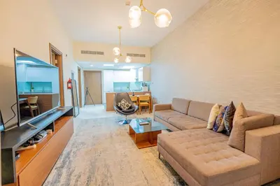 a living room with a couch and a flat screen tv at Premium 1BR King Bed Dubai Healthcare City in Dubai