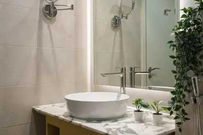 a bathroom with a sink with two plants on a counter at 5-Star Living | Luxury 2B & Amenities in Dubai