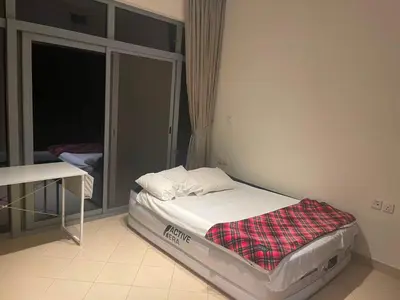 a small bed in a room with a window at Stunning rooms in the Canal in Dubai