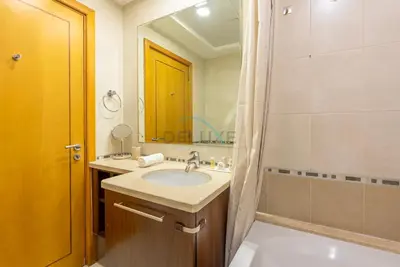 a bathroom with a sink and a tub and a mirror at Marina Canal View Apartment, Walking Distance to The Metro and Tram, Near The Beach and Top Dining - Bayside Residence, Dubai Marina by Deluxe Holiday Homes in Dubai