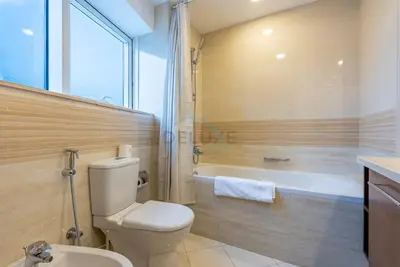 a bathroom with a toilet and a bath tub at Marina Canal View Apartment, Walking Distance to The Metro and Tram, Near The Beach and Top Dining - Bayside Residence, Dubai Marina by Deluxe Holiday Homes in Dubai