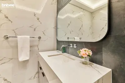 a bathroom with a white sink and a mirror at bnbmehomes - Tiara Residence in Dubai