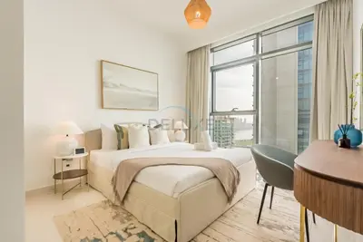 a bedroom with a bed and a desk and a window at Prime Waterfront Location with Stunning Palm Jumeirah Views, Close to Dubai Top Attractions - Beach Vista Tower 2, Emaar Beachfront by Deluxe Holiday Homes in Dubai