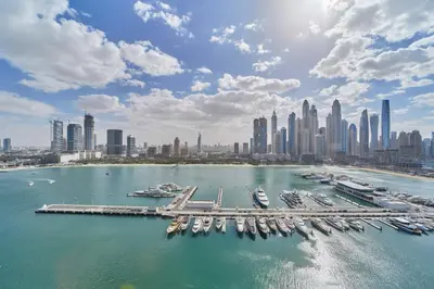 a group of boats docked in a harbor with a city at Elegant Beachfront 2BR at Palace Beach Residence in Dubai