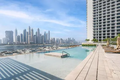 a swimming pool with a view of a city at Elegant Beachfront 2BR at Palace Beach Residence in Dubai