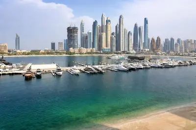 a group of boats docked in a harbor with a city at Elegant Beachfront 2BR at Palace Beach Residence in Dubai