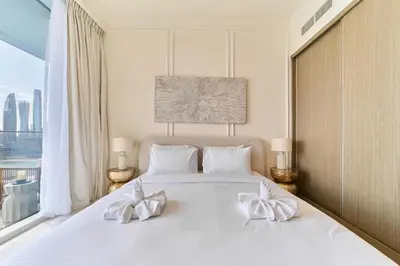 a bedroom with a large white bed with white bows at Elegant Beachfront 2BR at Palace Beach Residence in Dubai