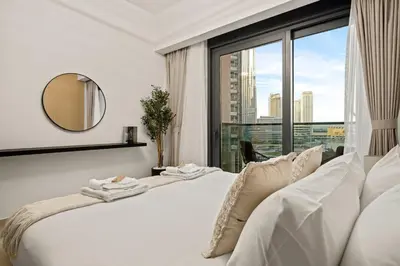 a bedroom with a white bed and a large window at Stunning 2BR with Full Burj View in the Opera District in Dubai