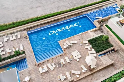 an overhead view of a swimming pool with chairs and tables at Chic 1BR at Reva Stunning Canal Views in Dubai