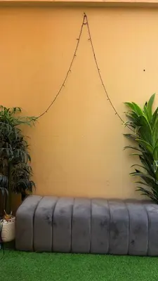 a couch sitting against a wall with a chain at 1 Bhk with open terrace in Dubai