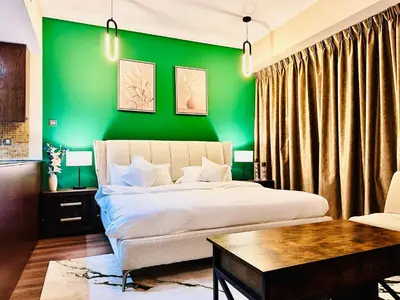 a bedroom with a green wall and a bed at Prime Modern Downtown Studio - Boulevard View in Dubai
