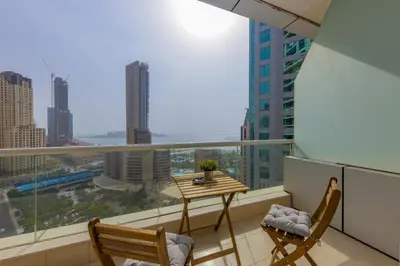 a balcony with a table and chairs and a view of a city at VayK - Amazing 1BR in Marina with Sea View in Dubai