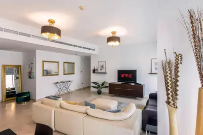 a living room with a couch and a tv at VayK - Modern 4BR in Dubai Marina with Sea View in Dubai