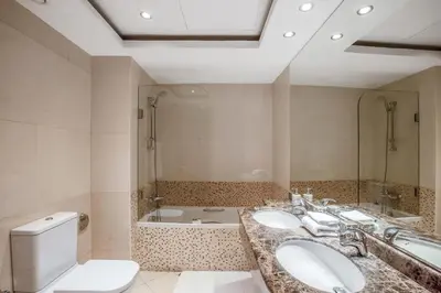 a bathroom with two sinks and a toilet and a tub at VayK - Modern 4BR in Dubai Marina with Sea View in Dubai