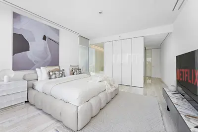 a white bedroom with a large bed and a tv at VayK - Ultra Luxury Muraba Residences in Palm in Dubai