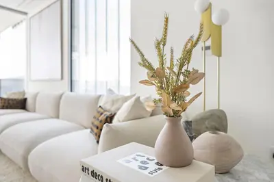 a white vase with flowers on a table in a living room at VayK - Ultra Luxury Muraba Residences in Palm in Dubai